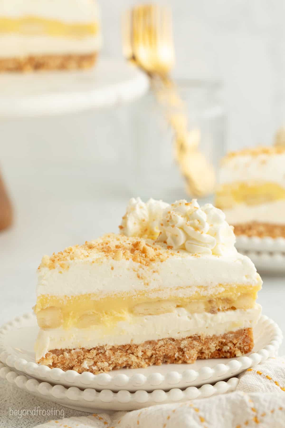 Make the best no-bake banana pudding cheesecake with creamy cheesecake filling, fresh banana slices, homemade pudding, and whipped cream. A slice of no-bake banana pudding cheesecake topped with whipped cream and Nilla wafer crumbs on a plate.