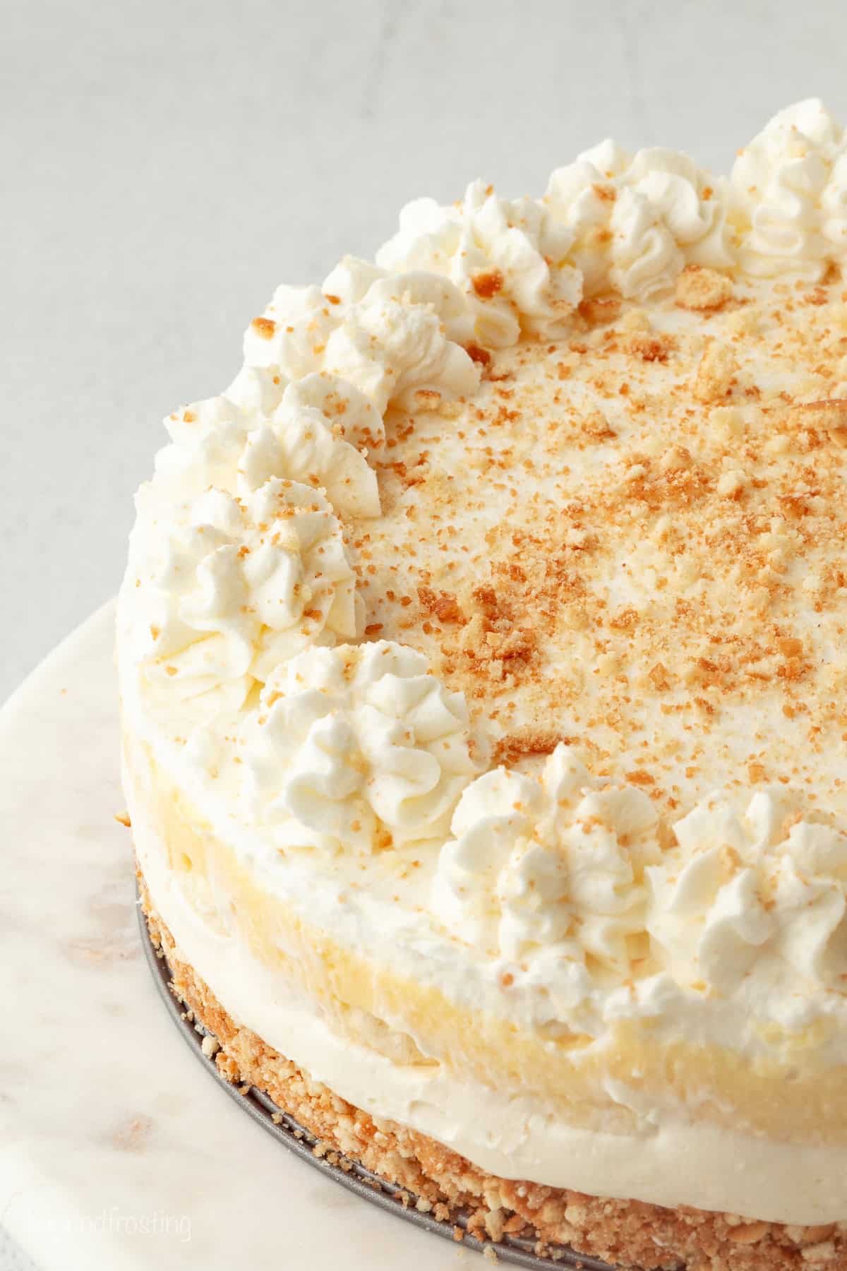 Make the best no-bake banana pudding cheesecake with creamy cheesecake filling, fresh banana slices, homemade pudding, and whipped cream. No-bake banana pudding cheesecake topped with whipped cream and garnished with Nilla wafer cookie crumbs.