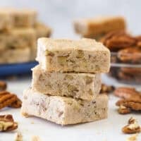 Three pecan shortbread cookies stacked on a countertop.