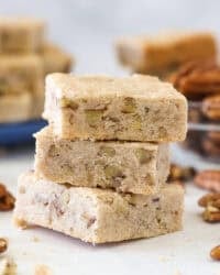Three pecan shortbread cookies stacked on a countertop.
