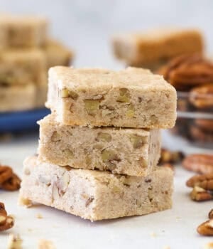 Three pecan shortbread cookies stacked on a countertop.