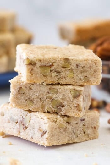 Three pecan shortbread cookies stacked on a countertop.