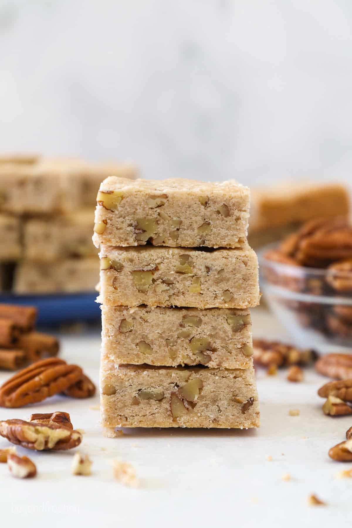 This easy pecan shortbread recipe makes soft, crumbly cookies filled with cinnamon, vanilla, and pecans. One bowl, no chilling or rolling! Four pecan shortbread cookies stacked on a countertop.