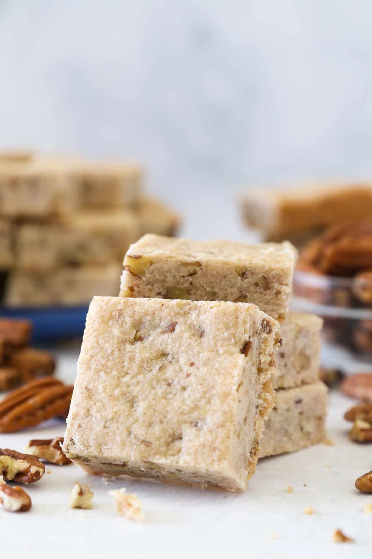This easy pecan shortbread recipe makes soft, crumbly cookies filled with cinnamon, vanilla, and pecans. One bowl, no chilling or rolling! A buttery pecan shortbread cookie propped up against a stack of cookies.