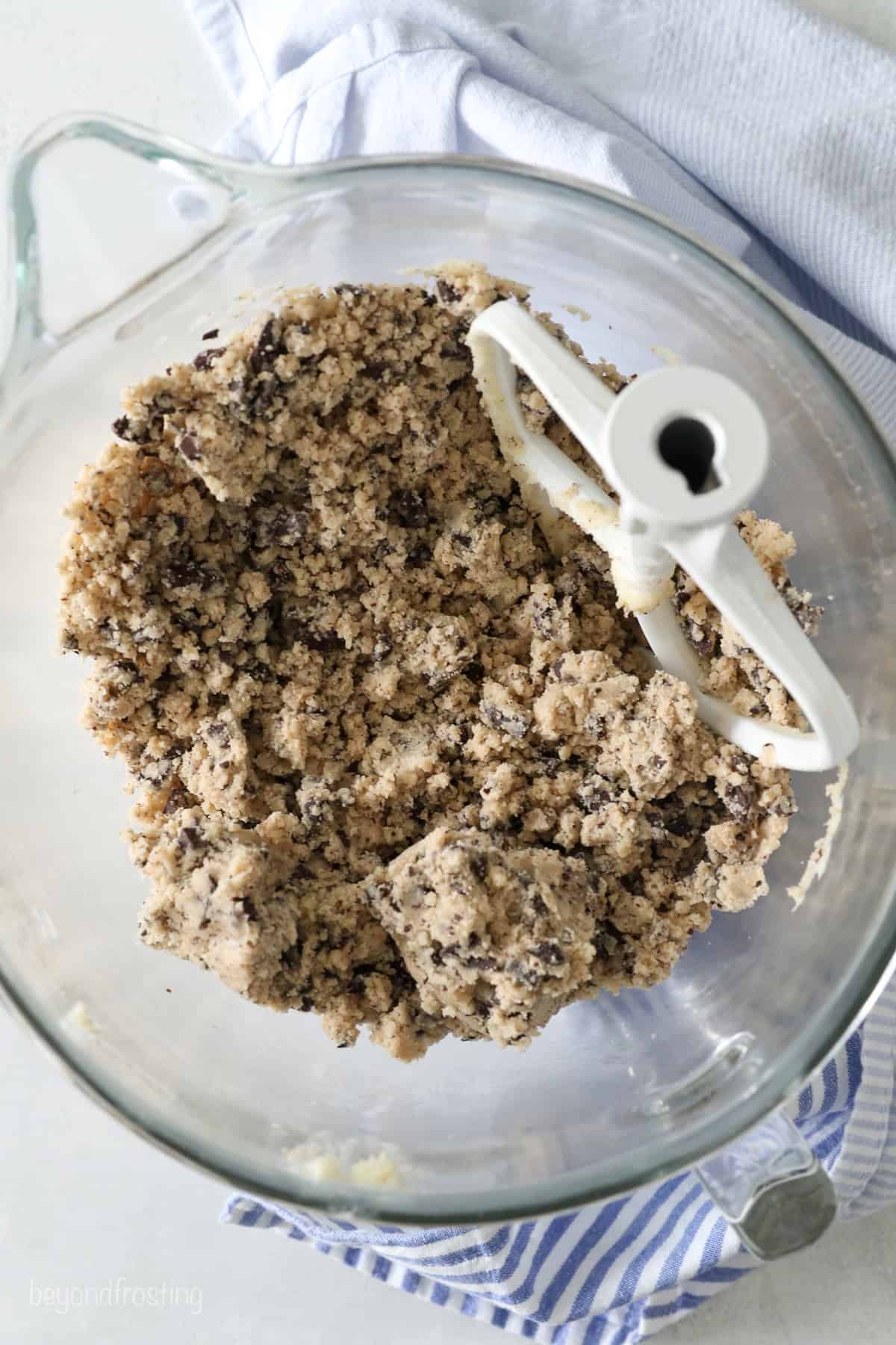 These classic, buttery shortbread cookies are filled with chopped chocolate and topped with a chocolate drizzle. Perfect for holiday baking! Chocolate chip shortbread cookie dough in a mixing bowl.