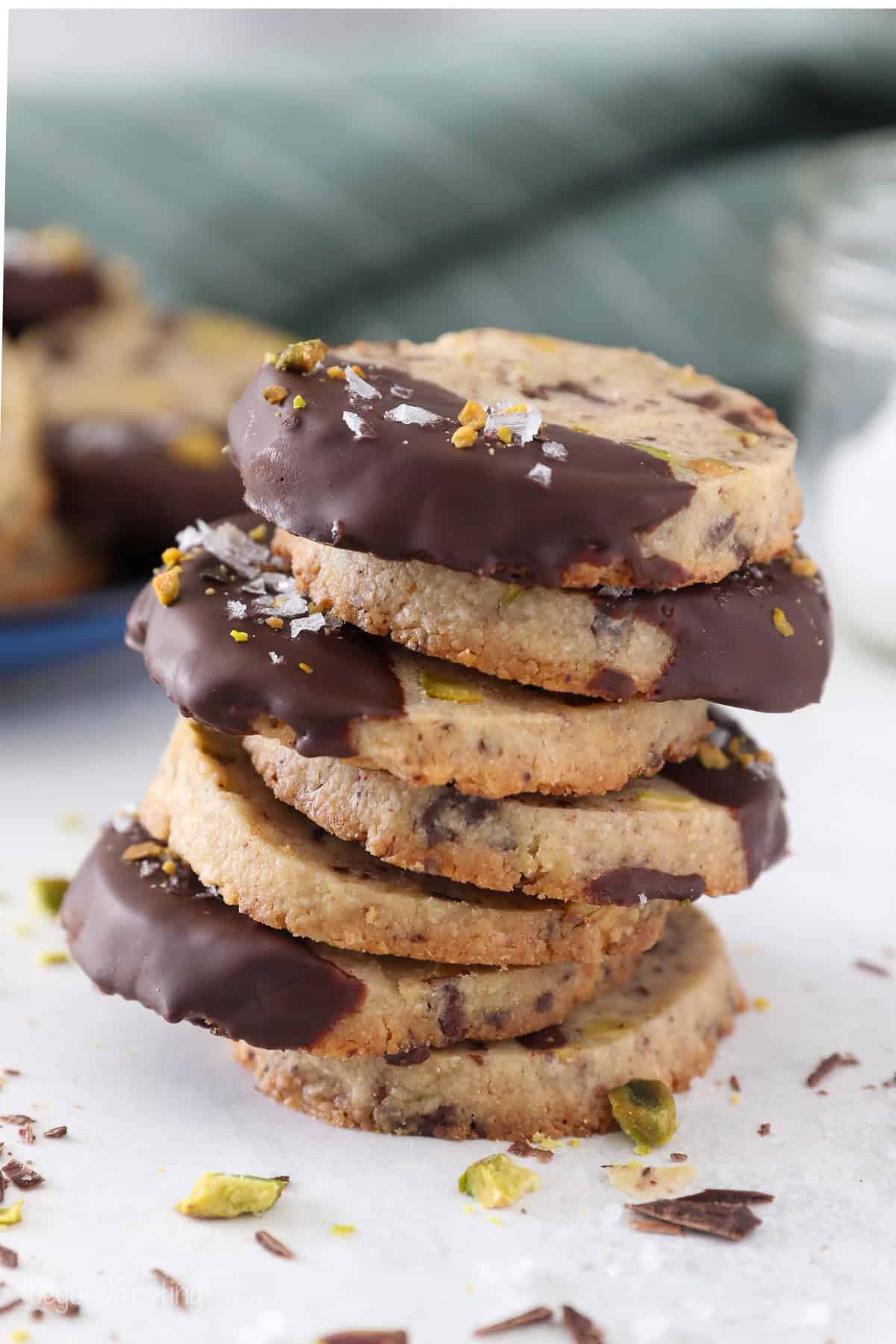 A stack of chocolate-dipped pistachio shortbread cookies.